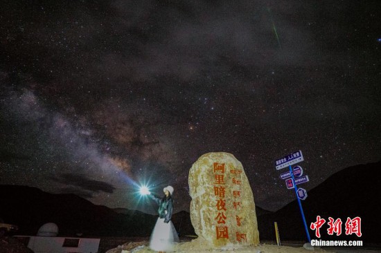 圖為6月20日晚，游客“打卡”西藏阿里暗夜公園，天上是銀河與流星（右上角）。曹枝清 攝
