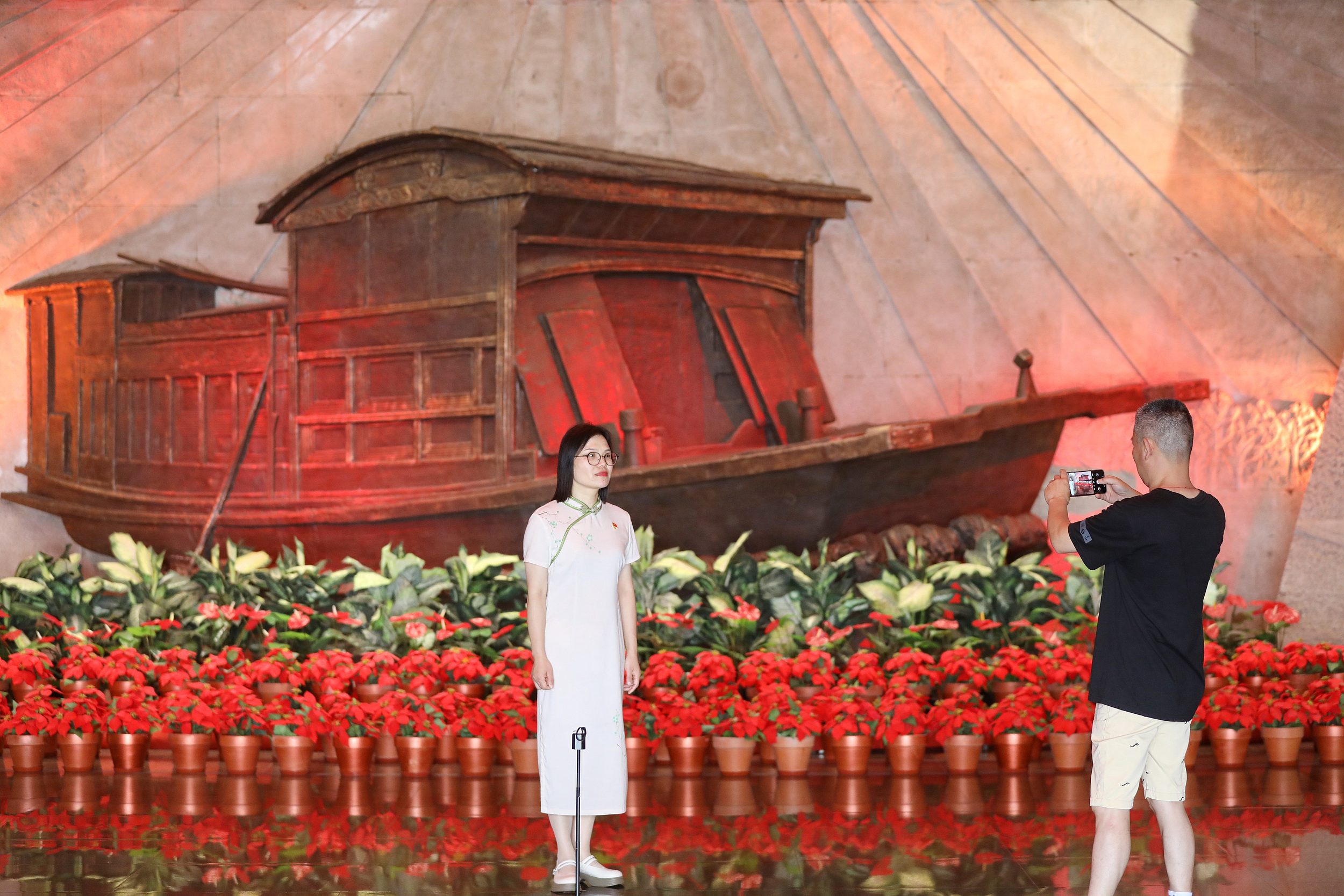 2025年6月24日,浙江嘉興,游客在南湖革命紀念館與紅船雕塑合影。(圖片來源:視覺中國)